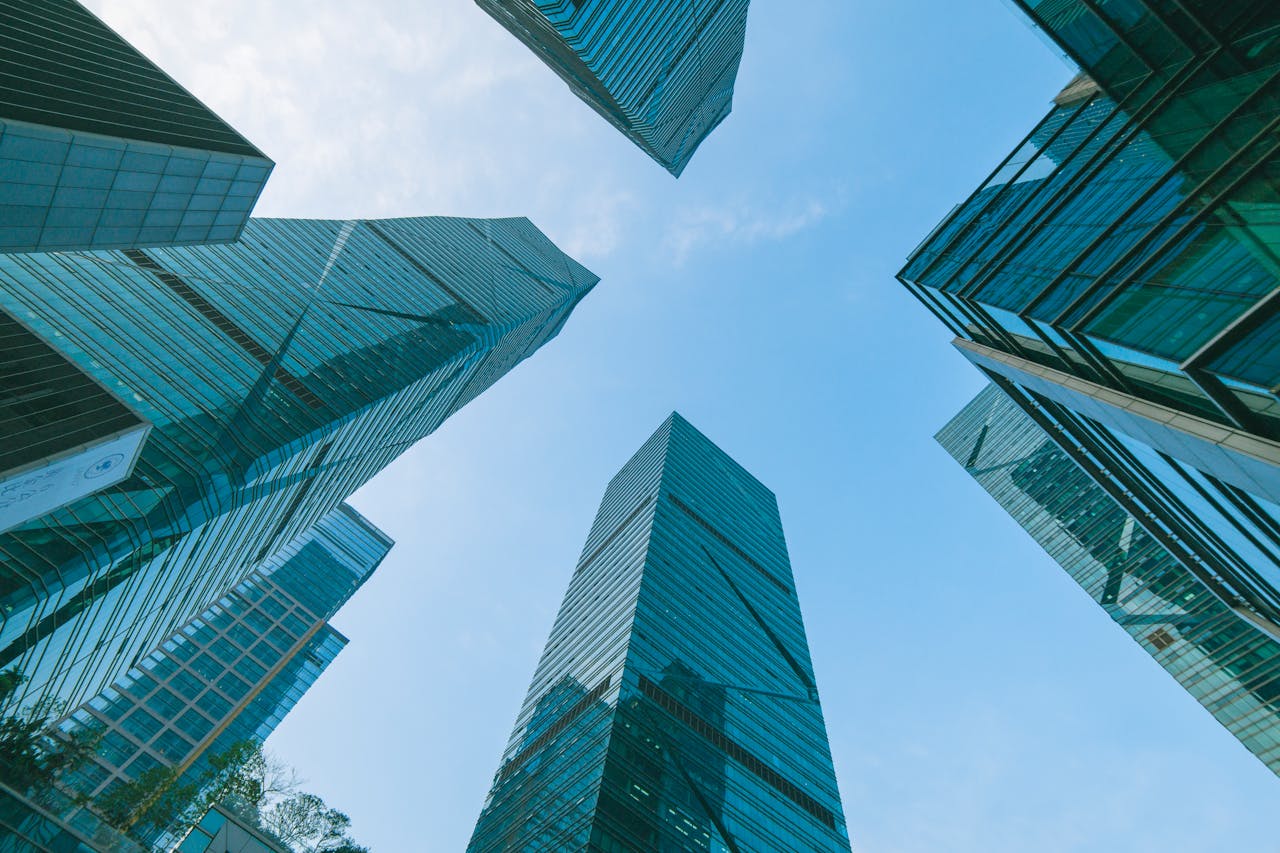 Blog Low angle view of contemporary skyscrapers in Shenzhen, China under a clear blue sky.